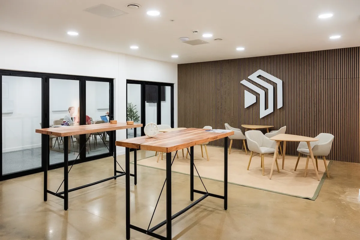 The Native Space lounge — wood-panelled wall, communal high tables and soft seating